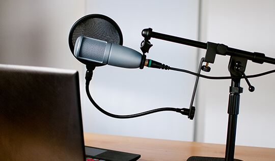 Recording microphone set up in front of a laptop.