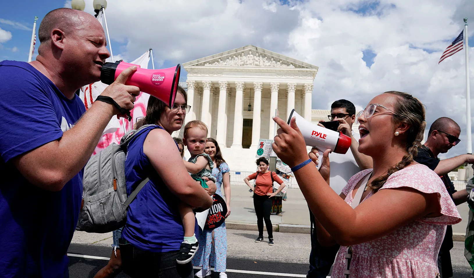Abortion rights activists and counter protesters face each other, both yelling into megaphones, protesting  outside the U.S. Supreme Court, in Washington DC