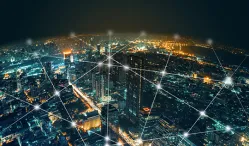 Nighttime birds eye view of a city with interwoven web of lines that connect the city in an energy grid. iStock/Chaay Tee