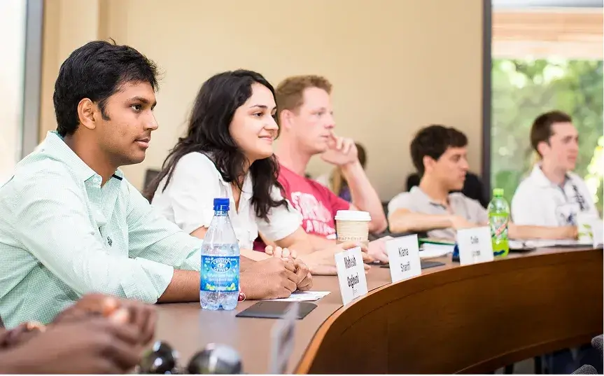 Students in a lecture in a GSB classroom, about 6 students in the shot listening.