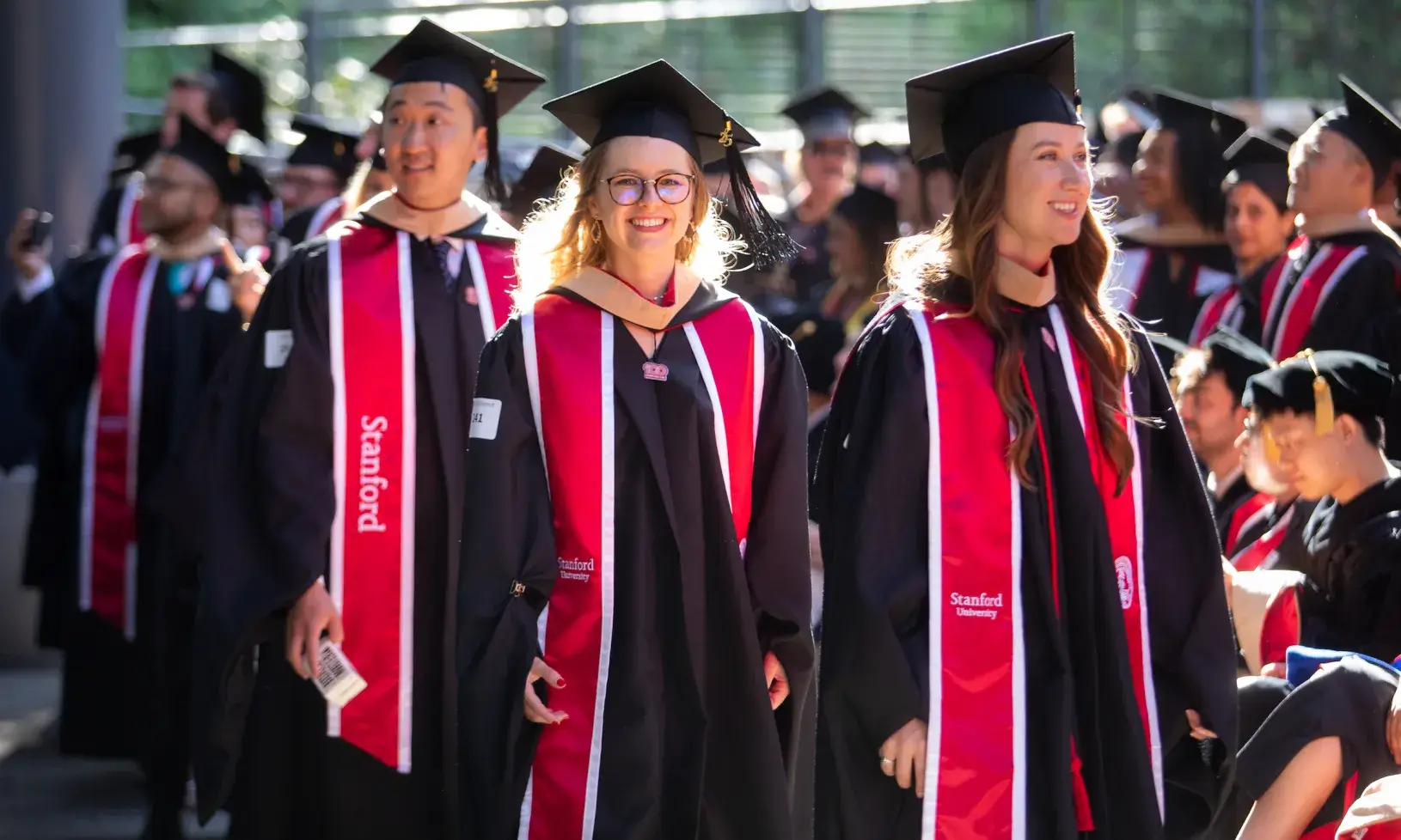 Grads in caps and gowns on campus at GSB