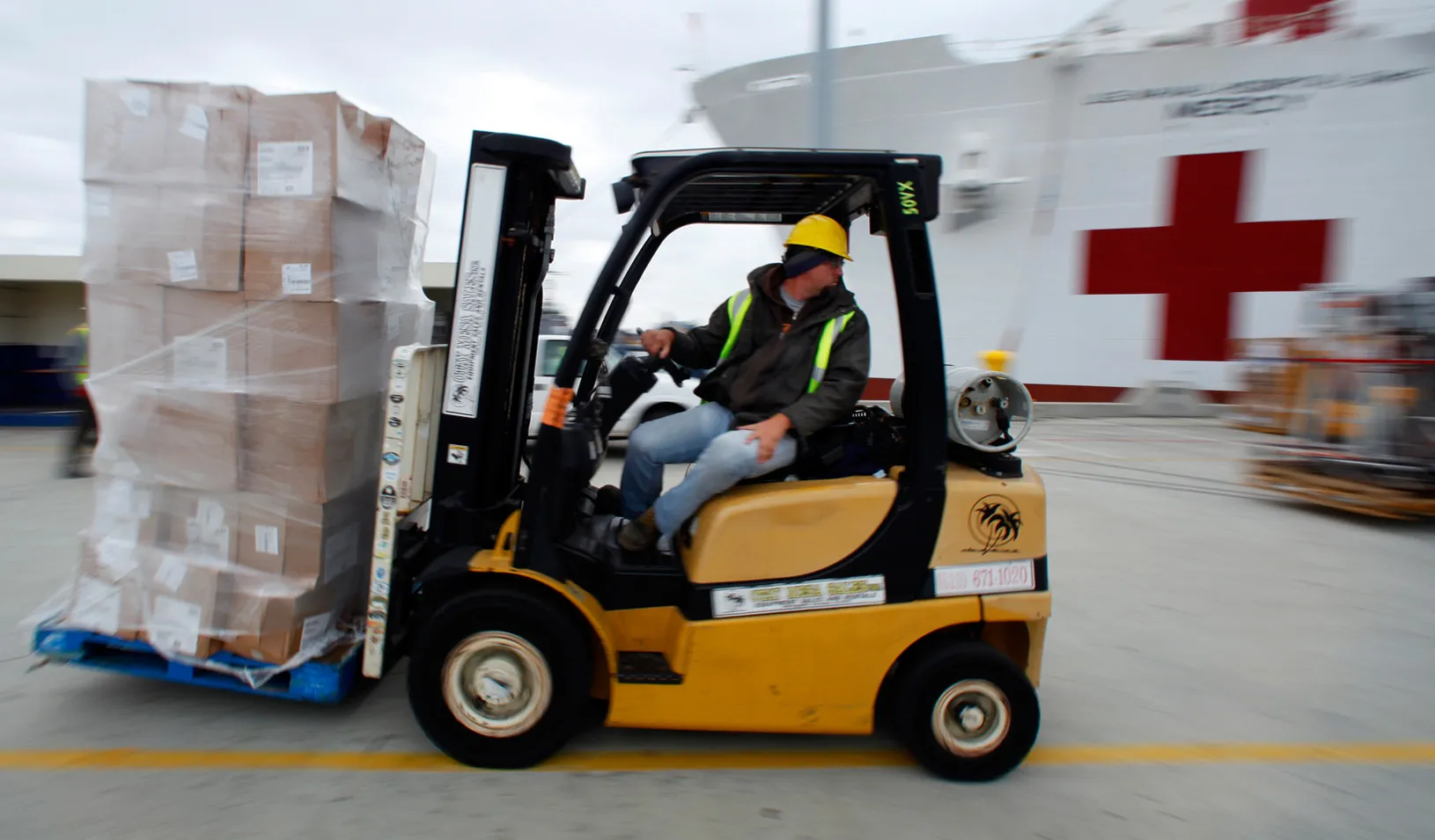 A worker loads supplies ship as a ship prepares for possible deployment to aid the typhoon-stricken areas of the Philippines. (Photo by Mike Blake)