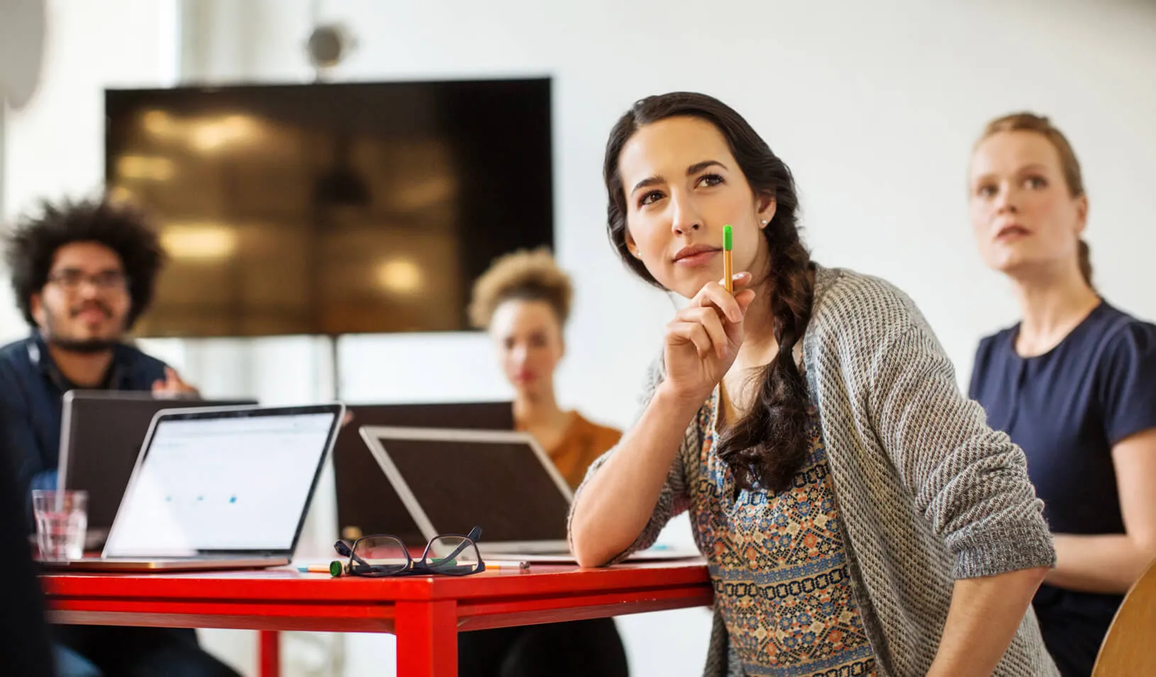 Young colleagues watching a presentation in a conference room | iStock/Alvarez