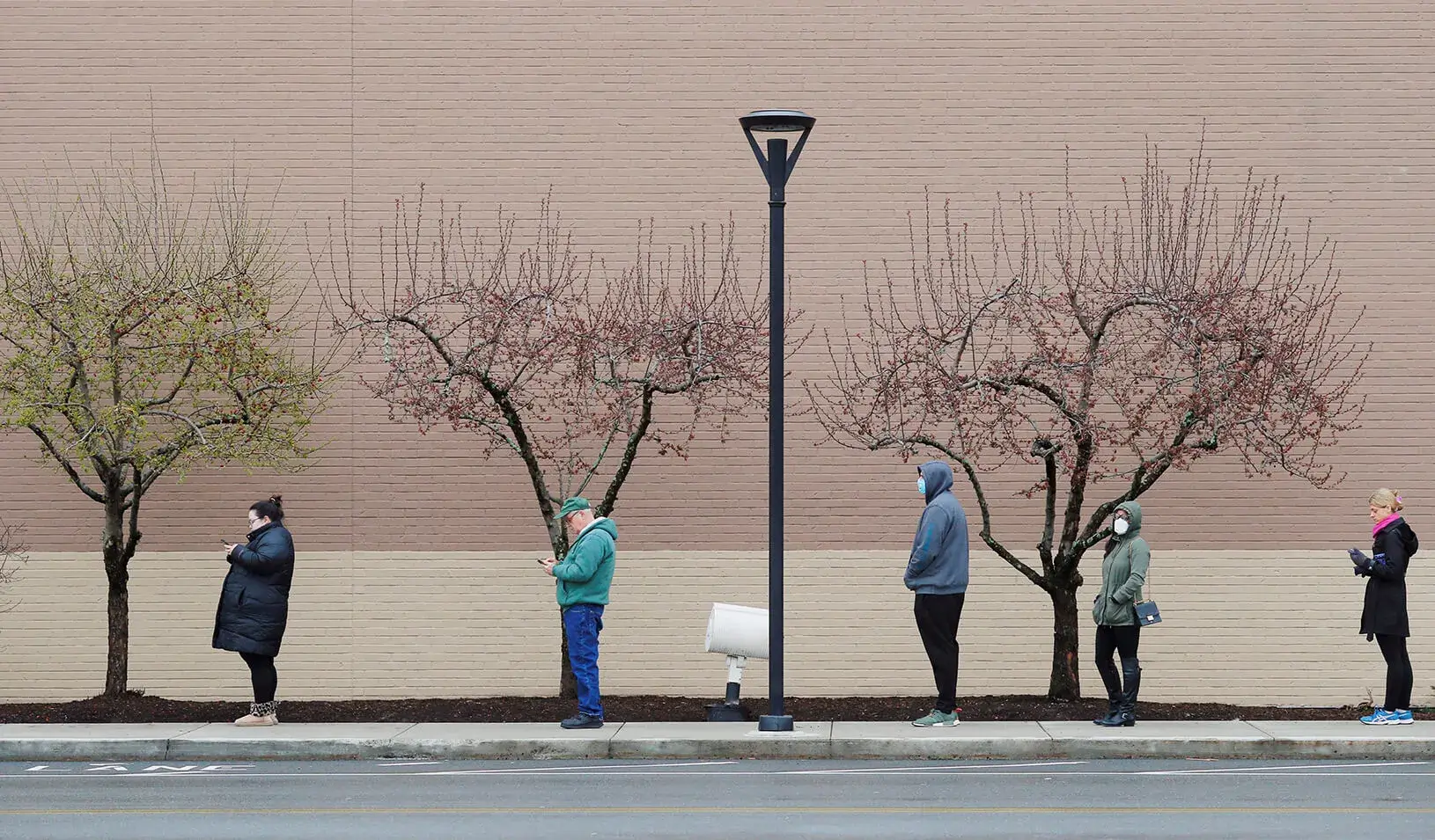 People line up at a safe social distance outside the grocery store amid the coronavirus disease (COVID-19) outbreak. Credit: Reuters/Brian Snyder