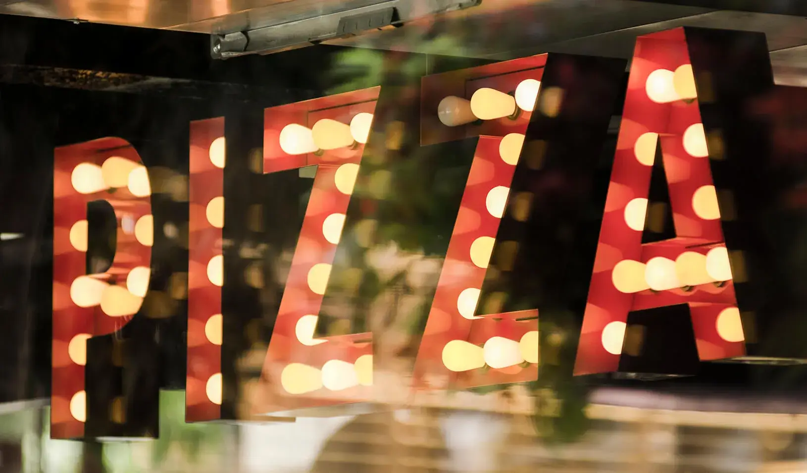 A neon "Pizza" sign