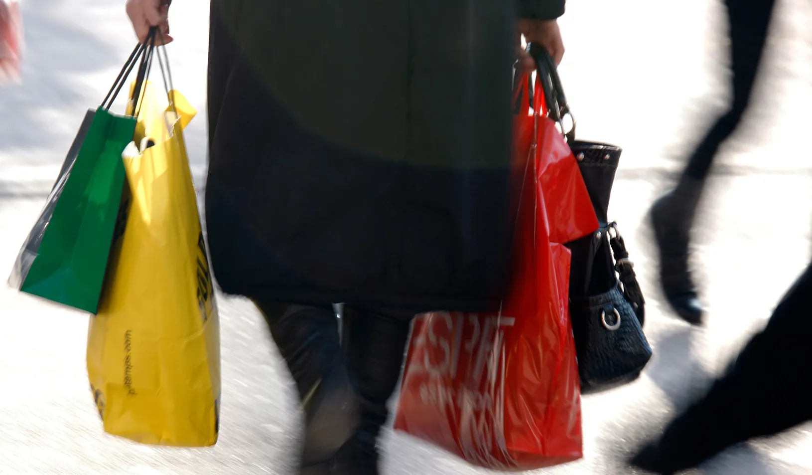 A woman carries shopping bags