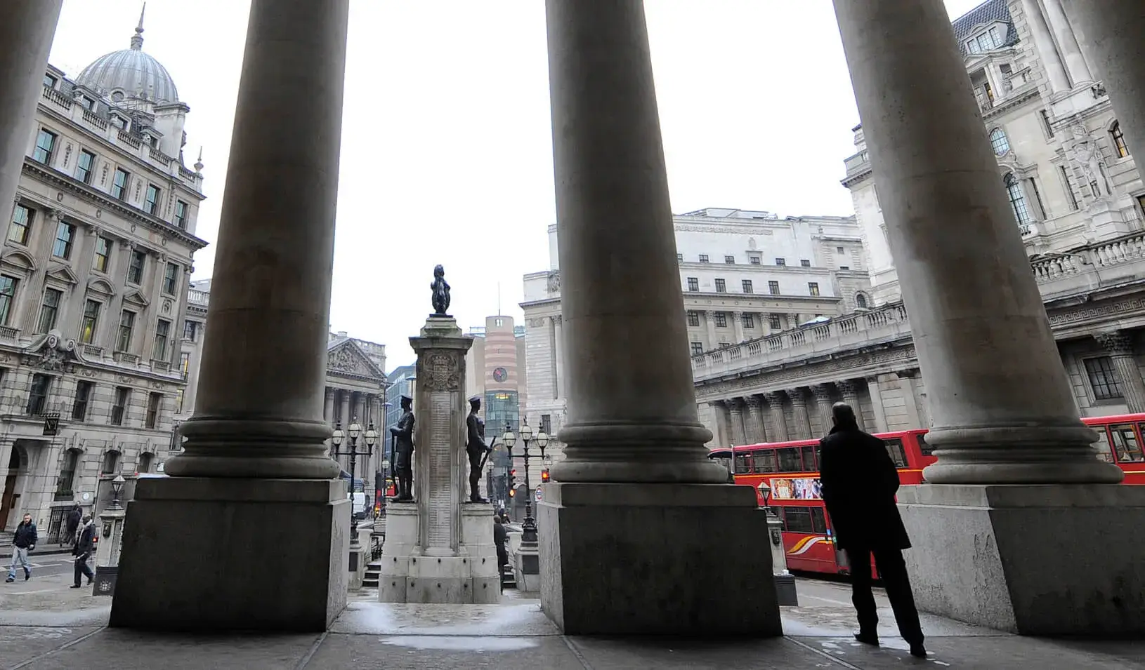 People walk through the Royal Exchange with the Bank of England (R) seen behind in central London. | REUTERS/Toby Melville