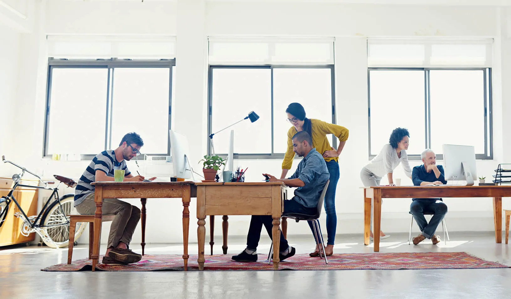 A diverse group of people working together​ | iStock/Yuri_Arcurs