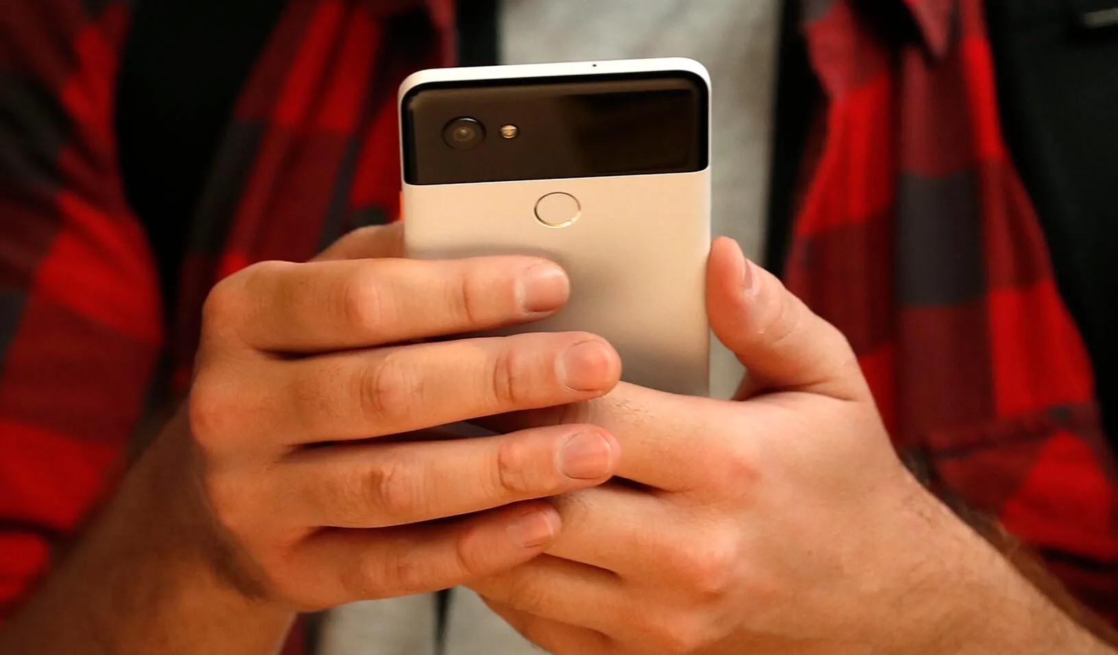 A man looks at his Google Pixel phone | Reuter/Stephen Lam