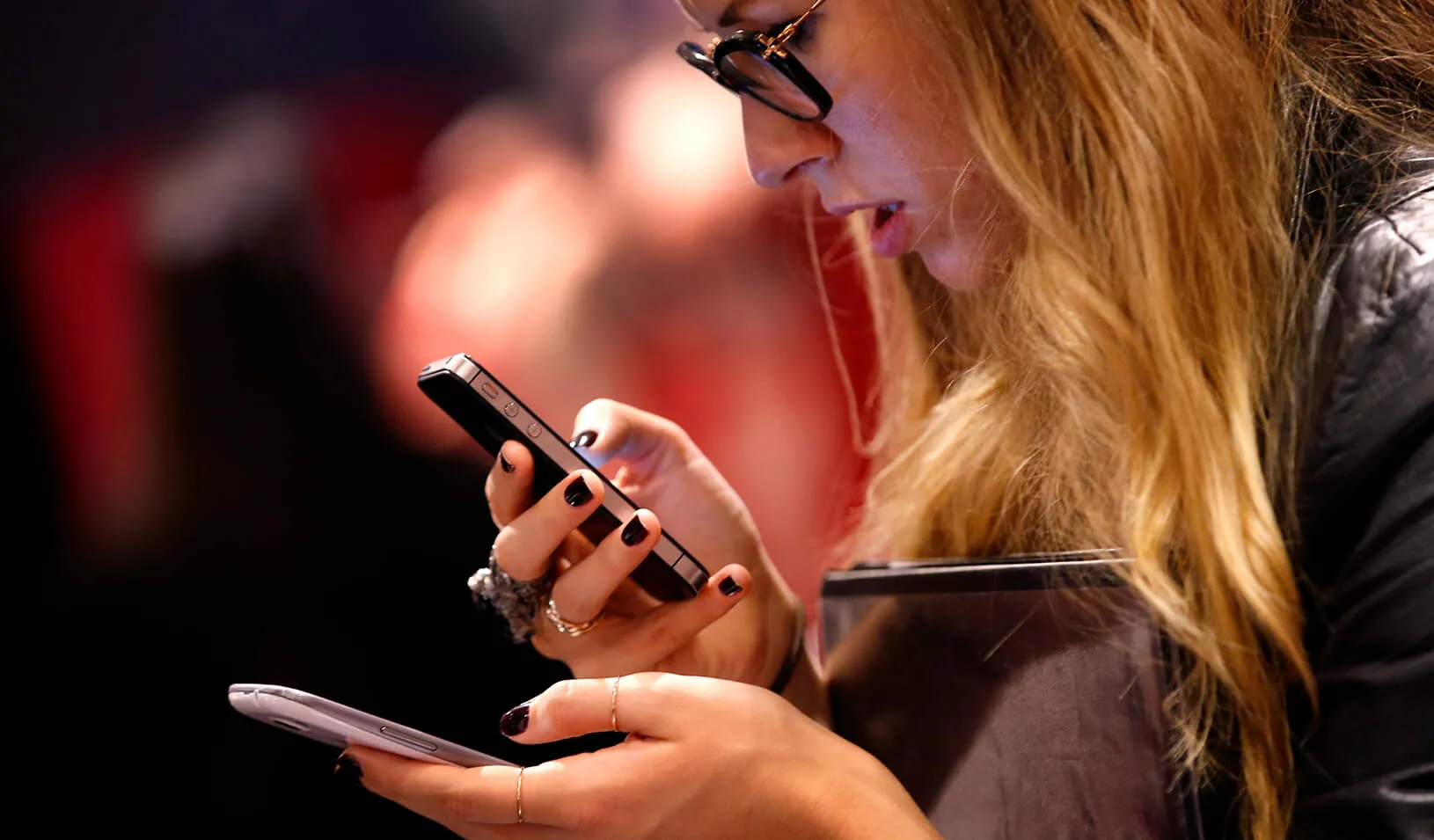 A woman looks at her cell phones | Reuters/Mike Segar