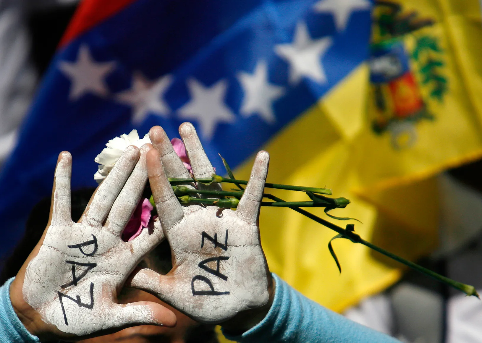 "Paz" - peace - painted on someone's hands