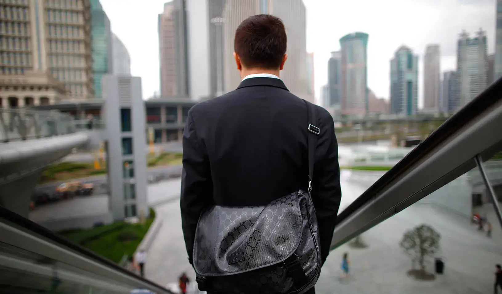 A business man rides an escalator | Reuters/Aly Song