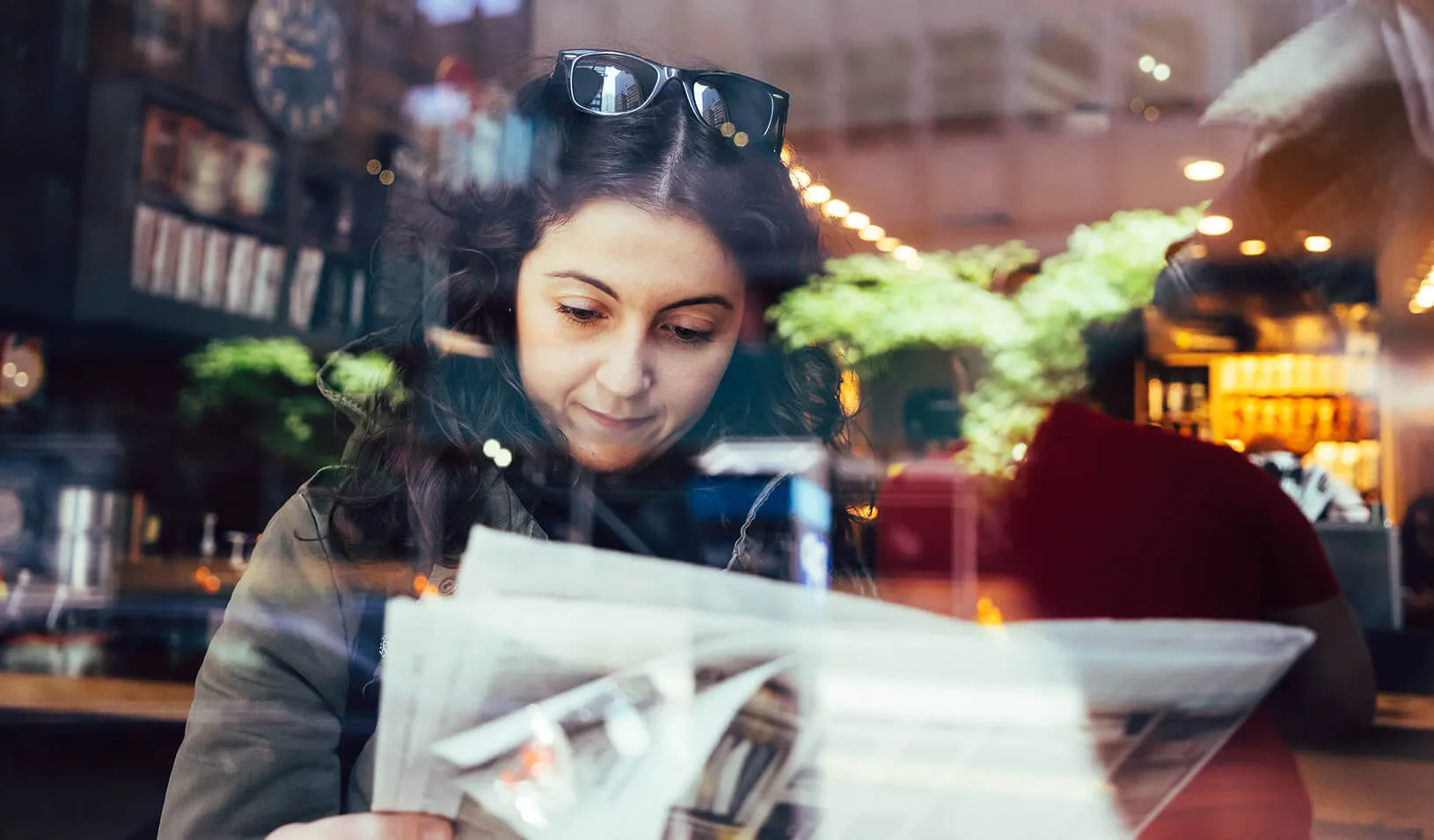 A woman reads a newspaper | iStock/FilippoBacci 
