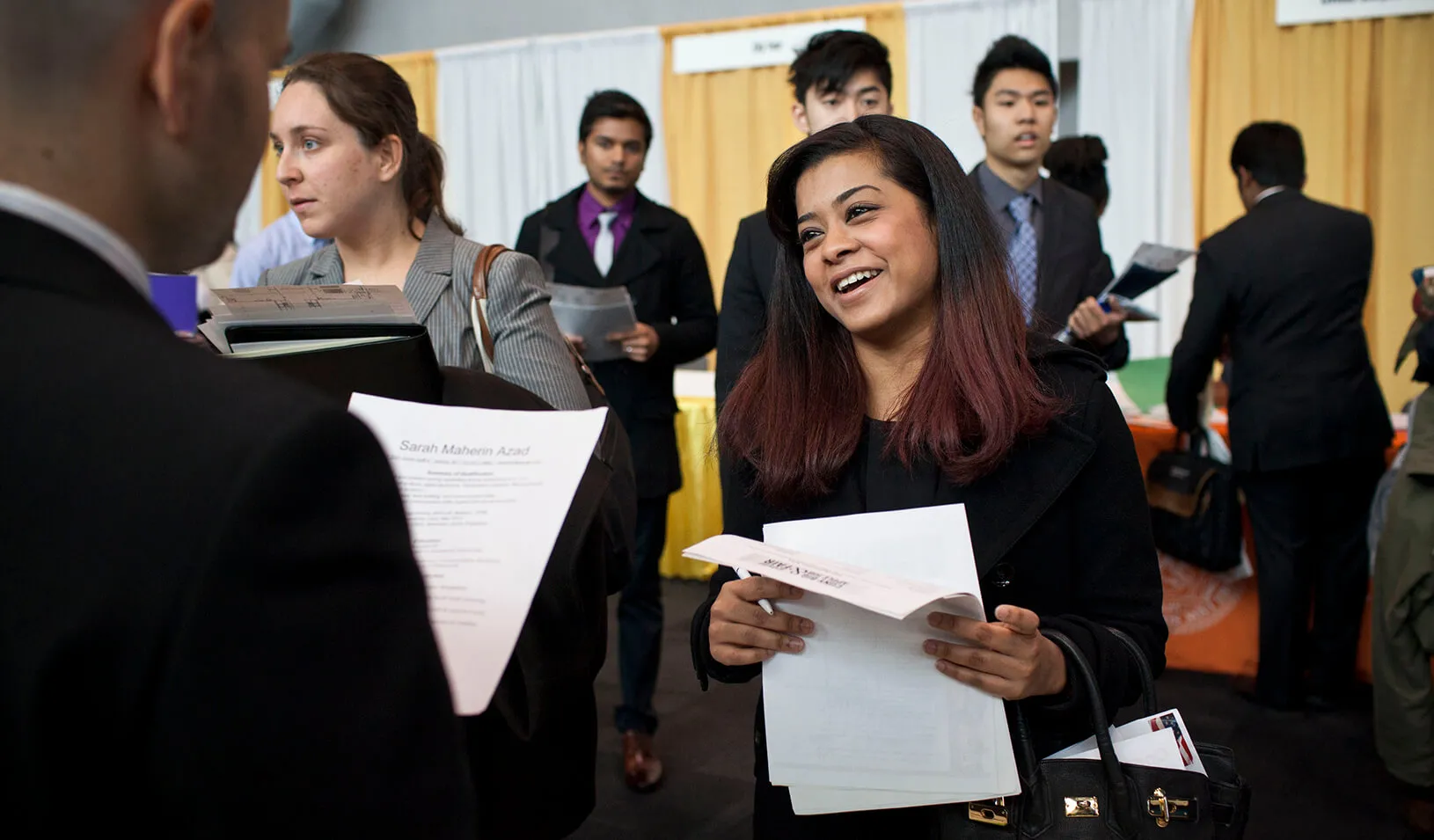 A female college senior meets a company representative at a job fair | Reuters/Andrew Burton