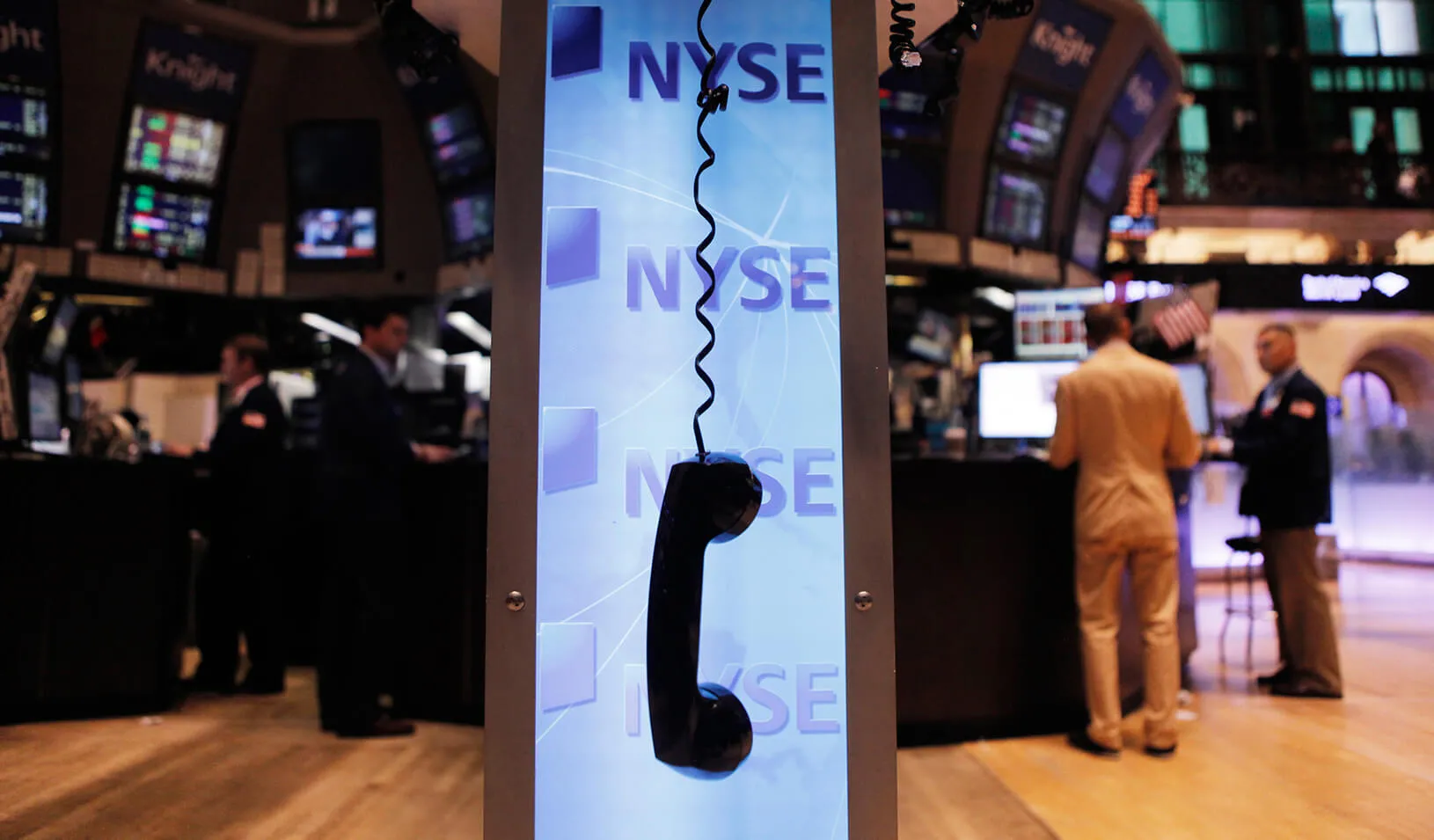 Telephone receiver hanging by its cord in front of the NYSE logo | Reuters/Lucas Jackson