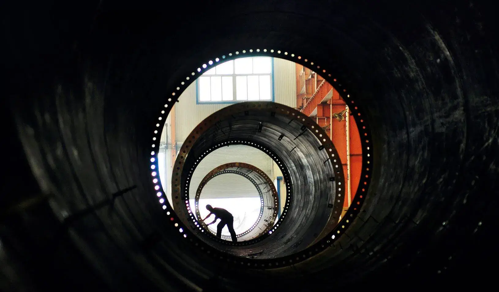 A laborer builds components of wind turbines at a wind power equipment factory. | Reuters/China Daily 