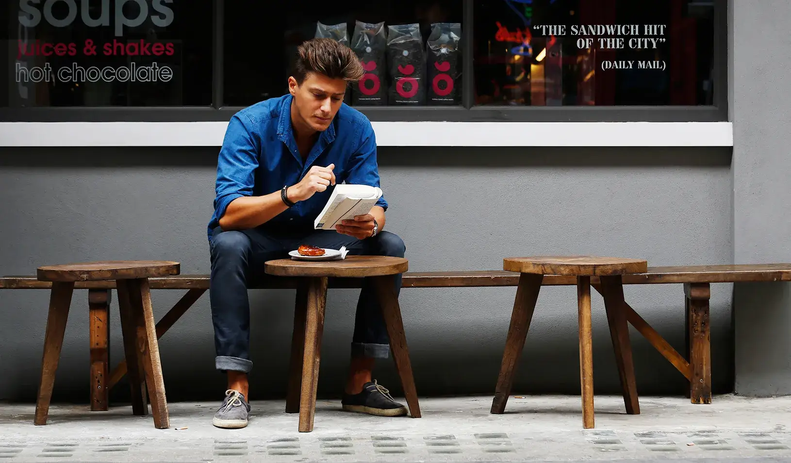 A man reads a book outside a cafe in London. | Reuters/Luke MacGregor