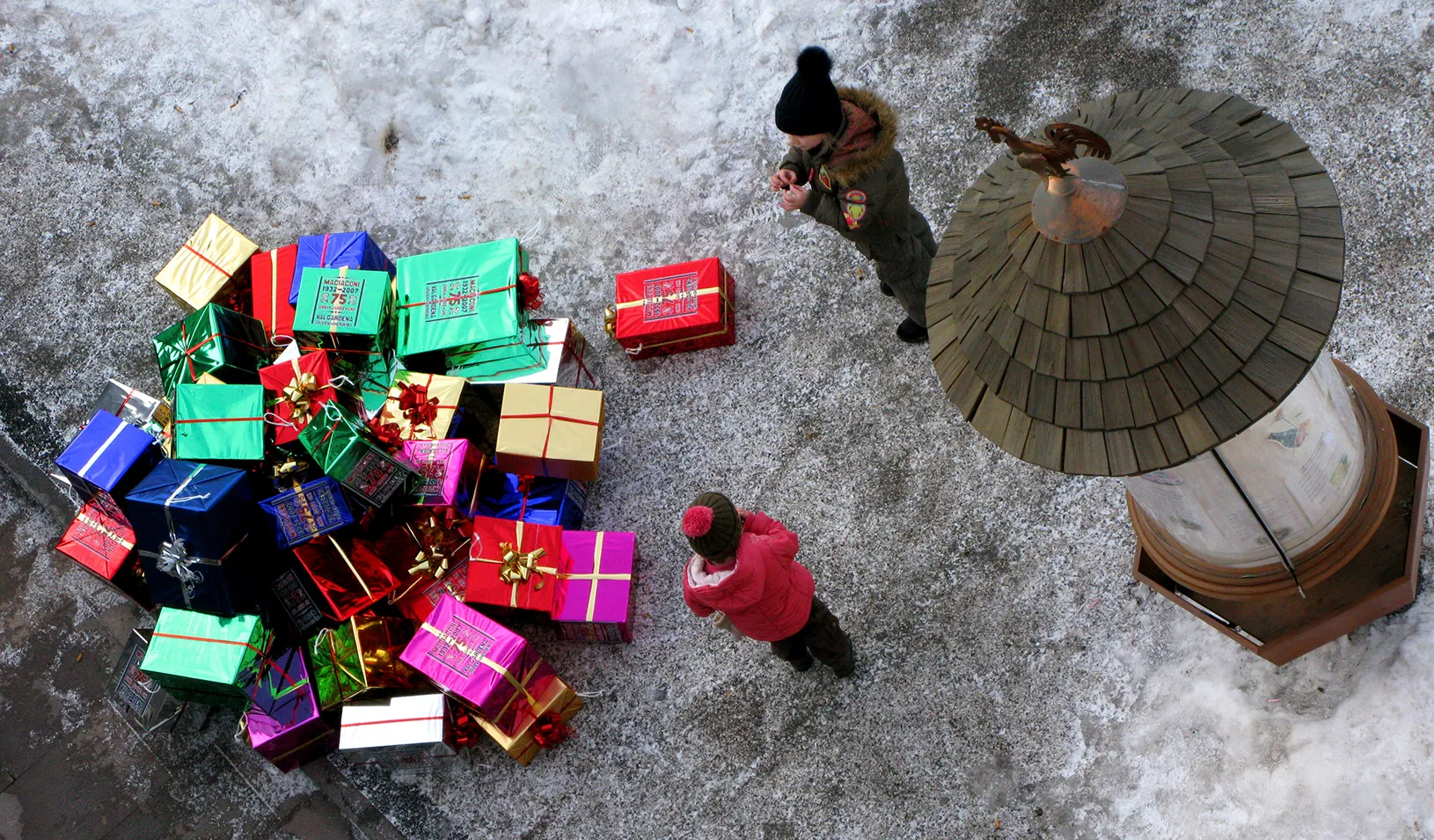 Children next to a pile of holiday gifts
