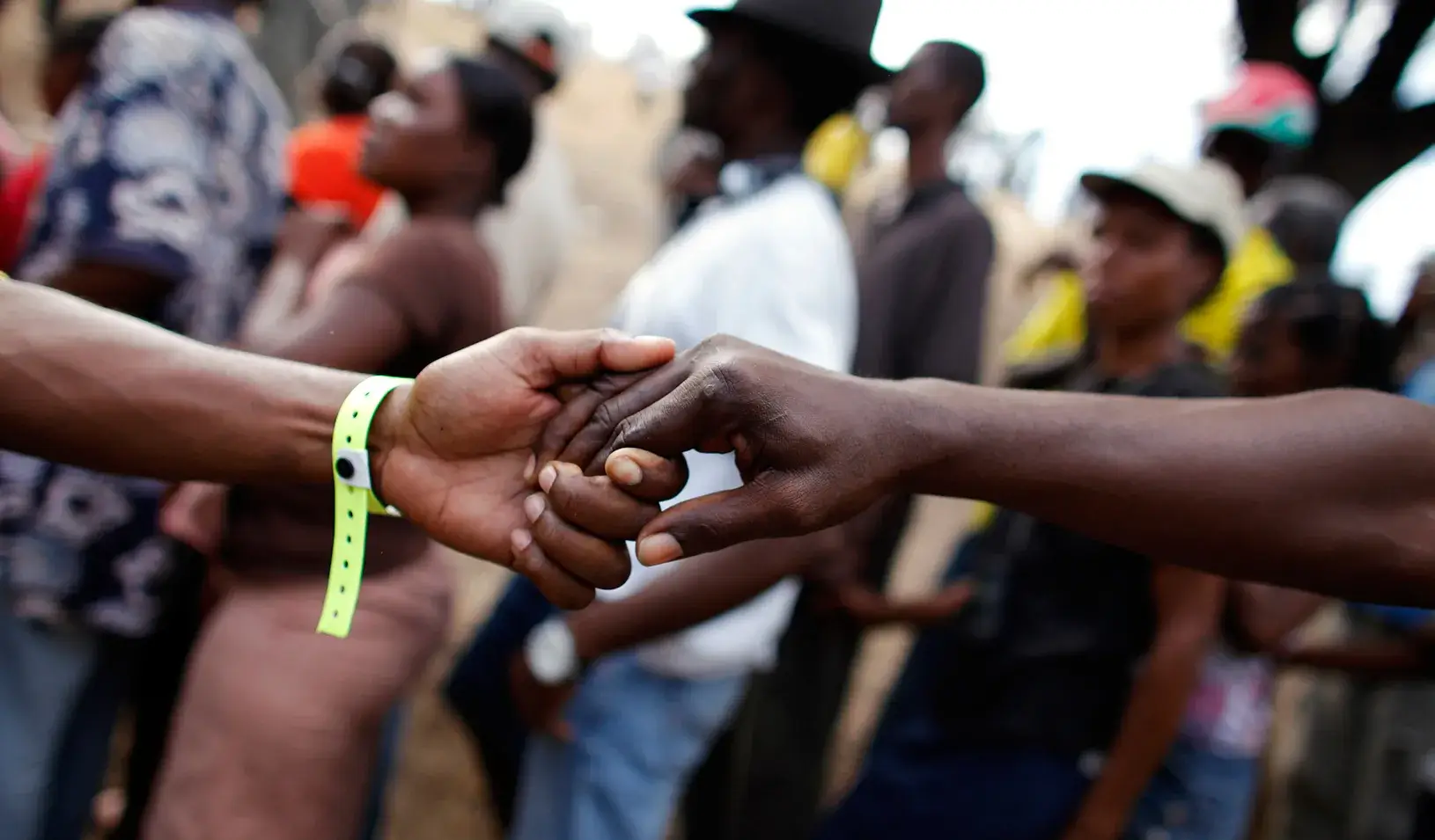 Hands clasping in a crowd