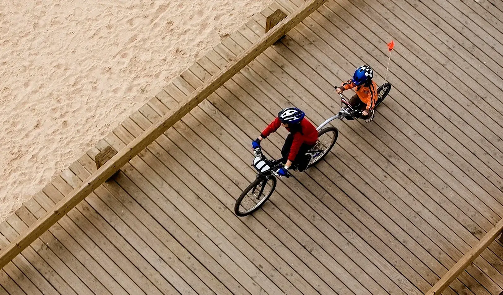 A parent and child ride a bicycle built for two along the beach. | Reuters/Nacho Doce