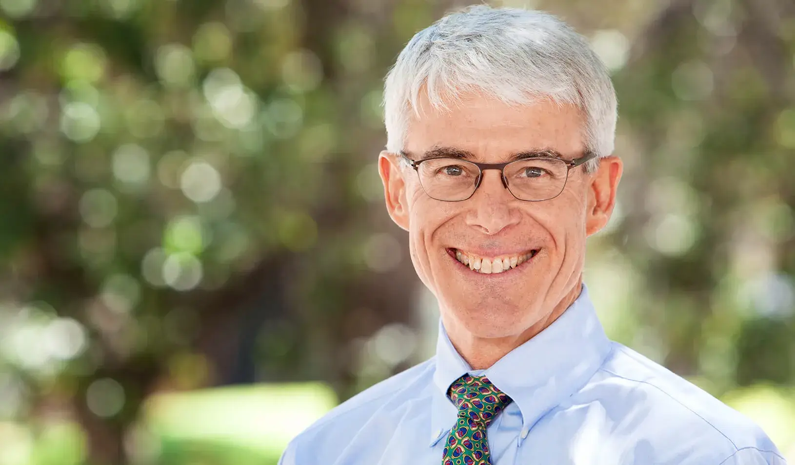 Professor of Management and Professor of Finance Darrell Duffie standing outside smiling at the camera. Credit: Nancy Rothstein