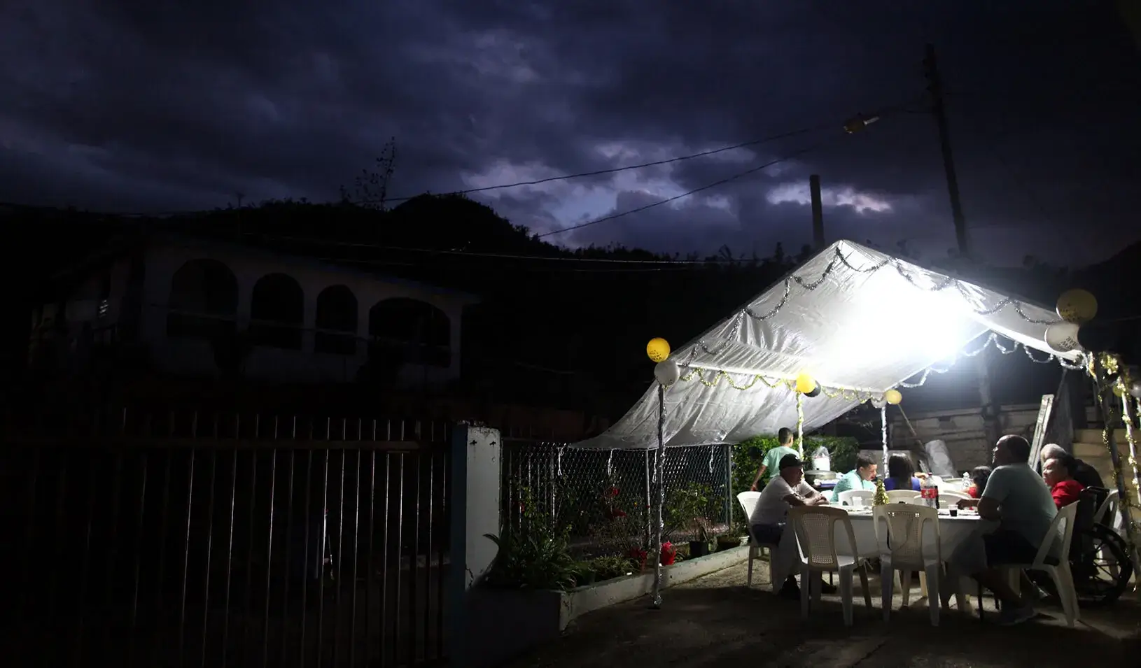 Residents of the El Salto neighbourhood share a meal during New Year's Eve after Hurricane Maria damaged the electrical grid in September, in Morovis, Puerto Rico December 31, 2017. | Reuters/Alvin Baez