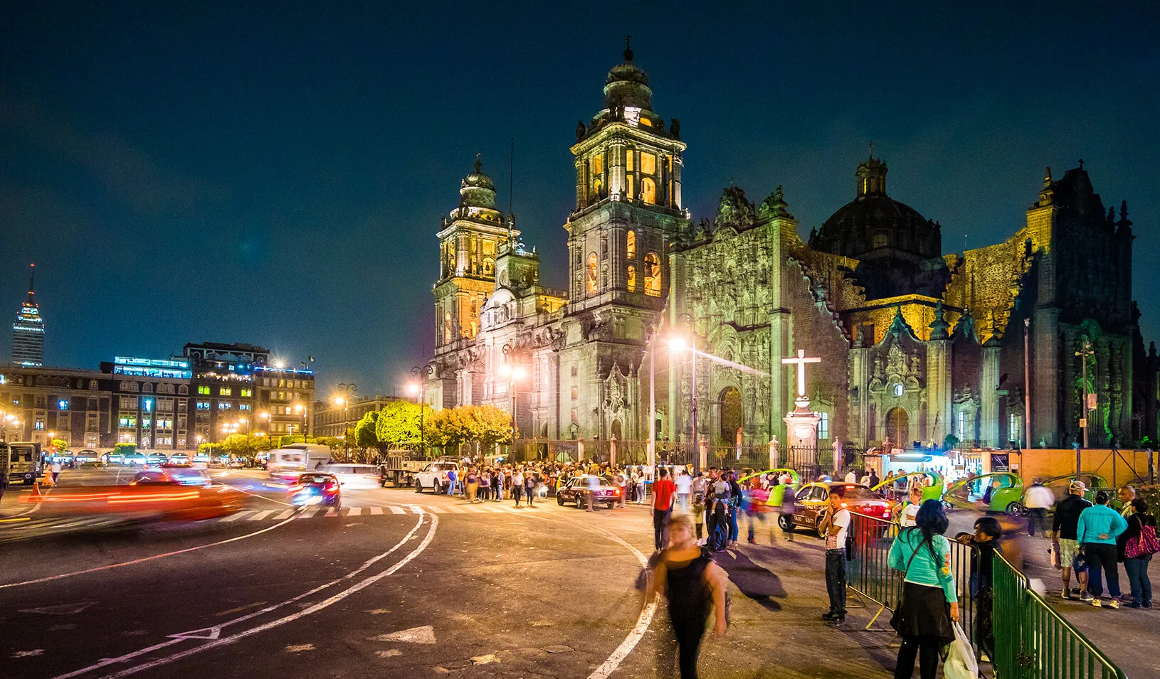 View of the busy street outside the Metropolitan Cathedral of the Assumption in Mexico City, Mexico at night. 