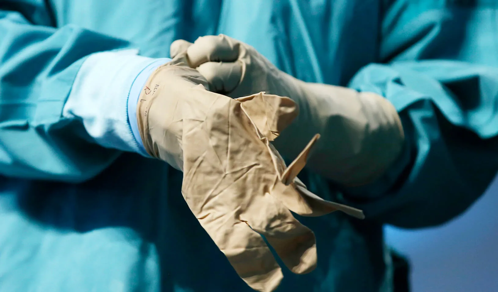 A nurse demonstrates putting on a second pair of protective gloves, Credit: Reuters/Mike Segar
