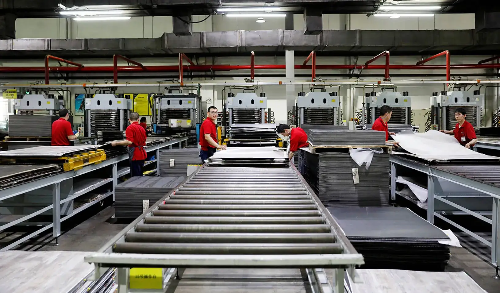 Employees work on a PVC plastic flooring production line. Credit: Reuters/Aly Song