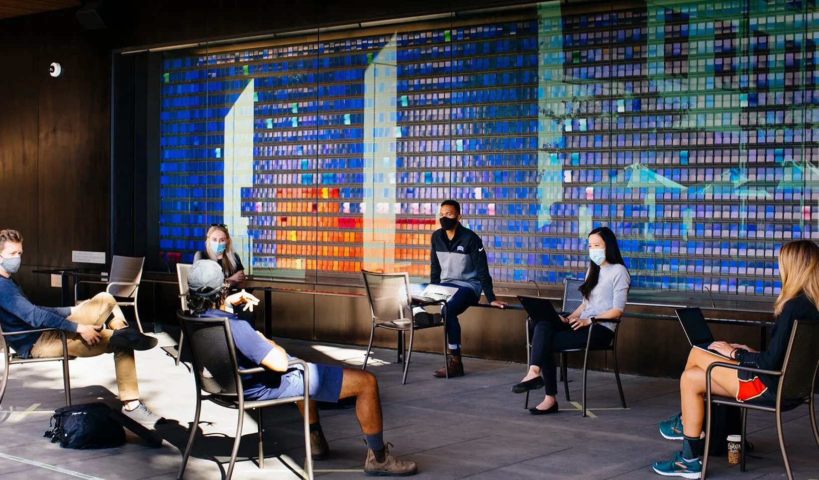Students, masked and distanced, study together in front of the color wall during fall quarter, 2020. Credit: Elena Zhukova
