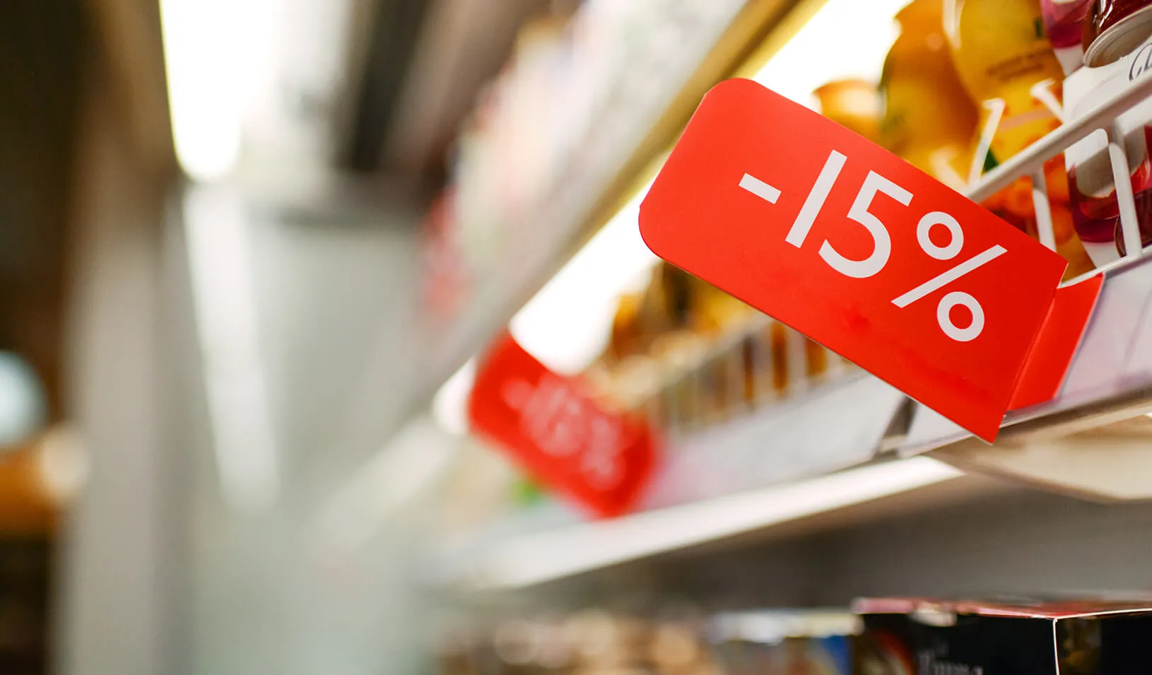 Grocery store shelves with price cut signs | iStock/anouchka