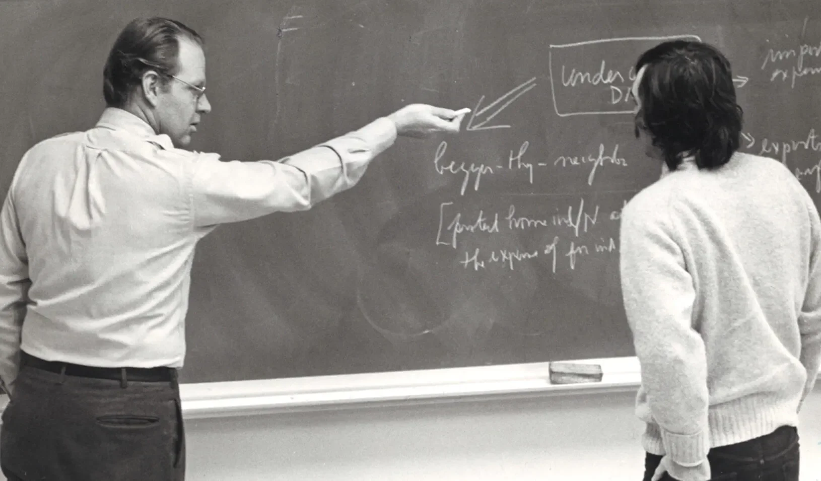 James Howell at chalkboard with student. Credit: Stanford GSB