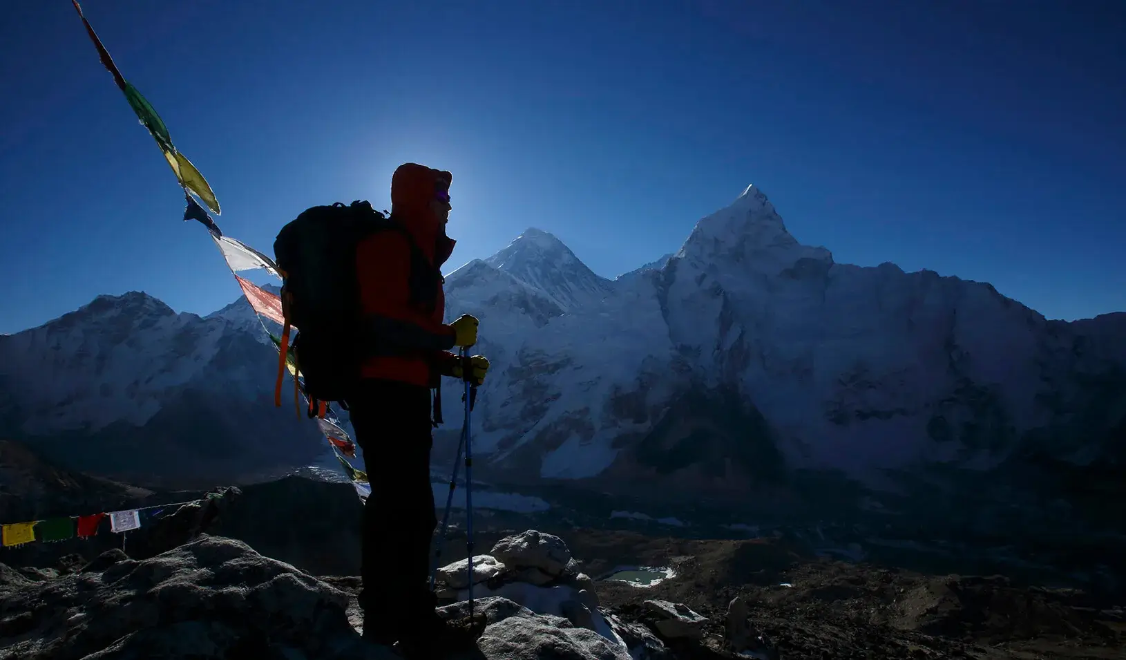 A trekker stands in front of Mount Everest