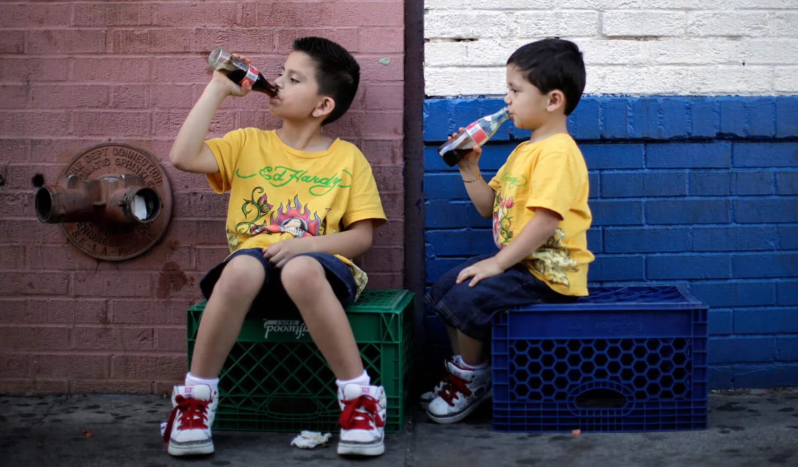 Children drink soda as they sit in the shade on a hot day. Credit: Reuters/Lucy Nicholson