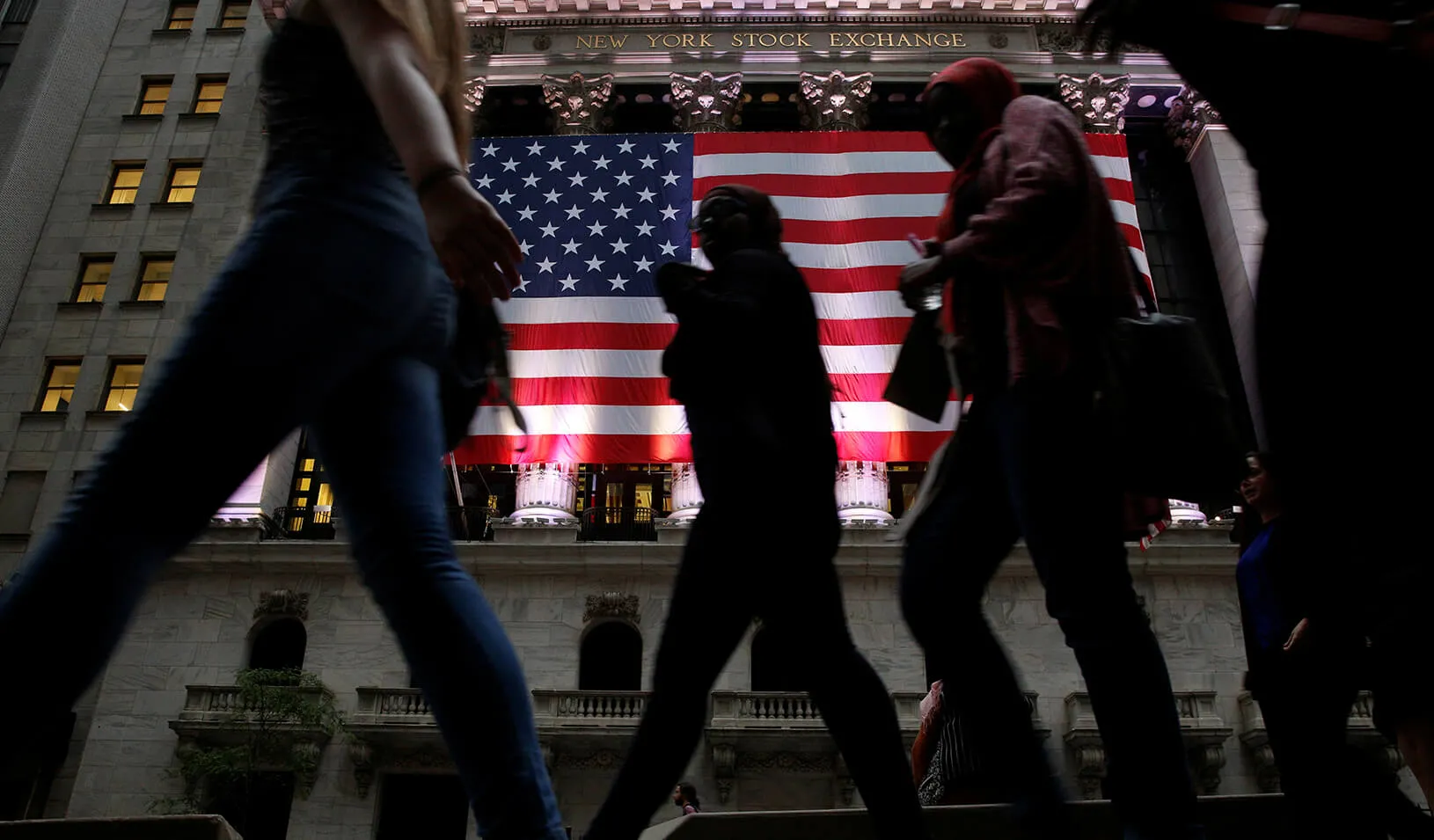People pass by the New York Stock Exchange (NYSE) in the financial district in Manhattan borough of New York City.