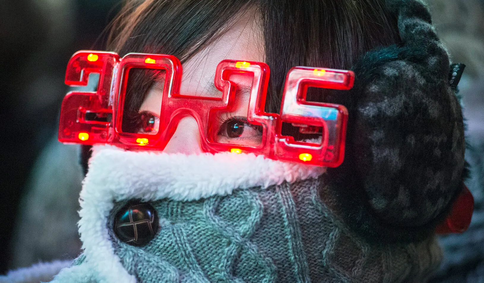 A woman wearing 2015 glasses during New Year's Eve celebrations