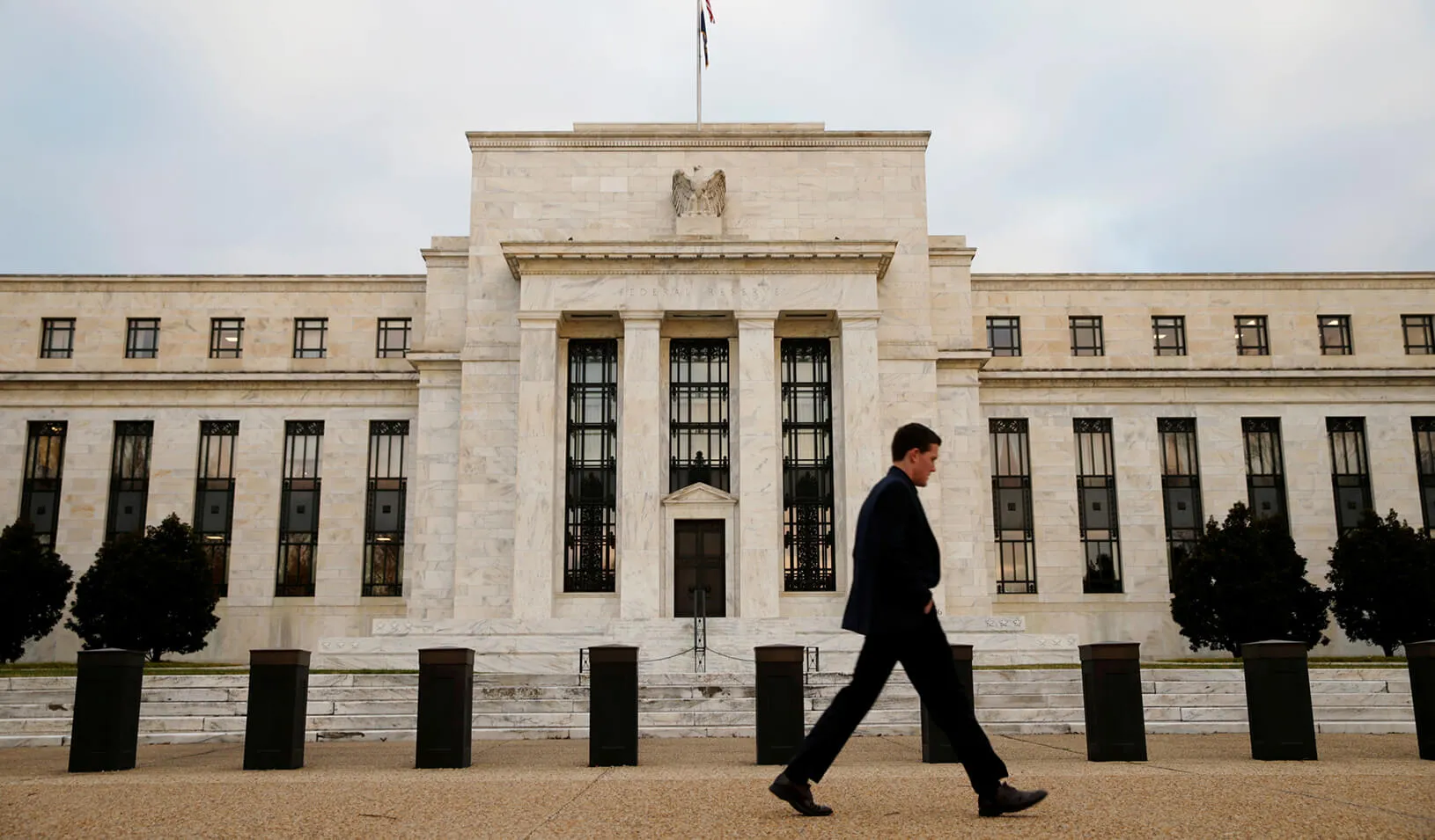 A man walks past the Federal Reserve Bank in Washington, D.C. 