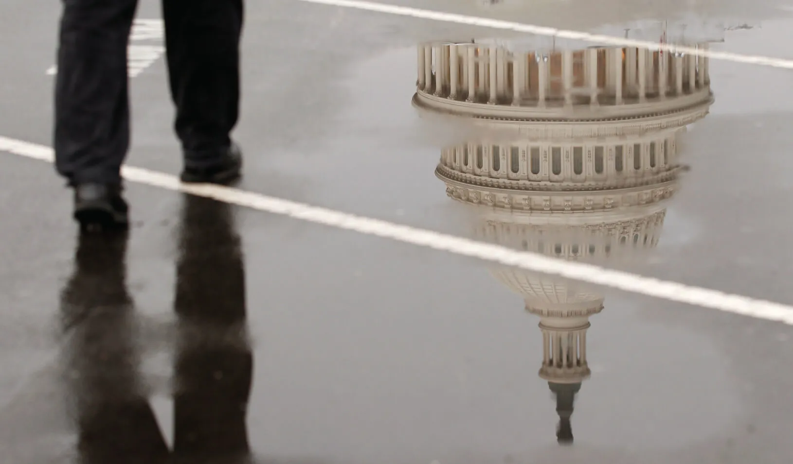 The dome of the U.S. Capitol Building is reflected in a puddle on a rainy morning. Credit: Reuters/Kevin Lamarque
