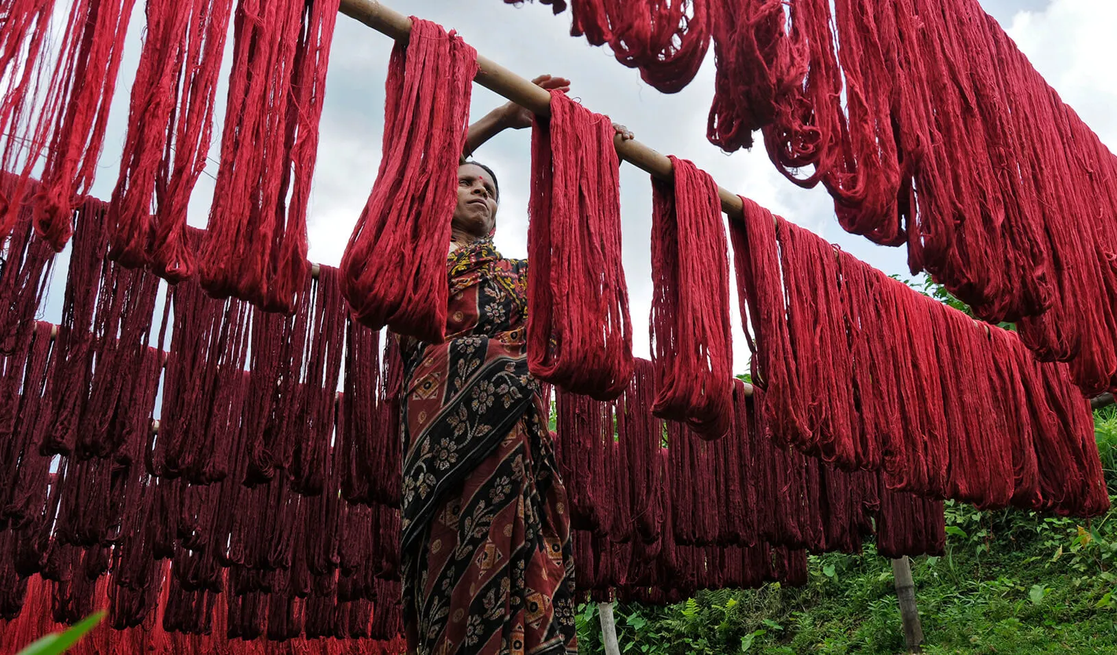 A woman hanging dyed yarn to dry at a textile mill on the outskirts of Agartala 