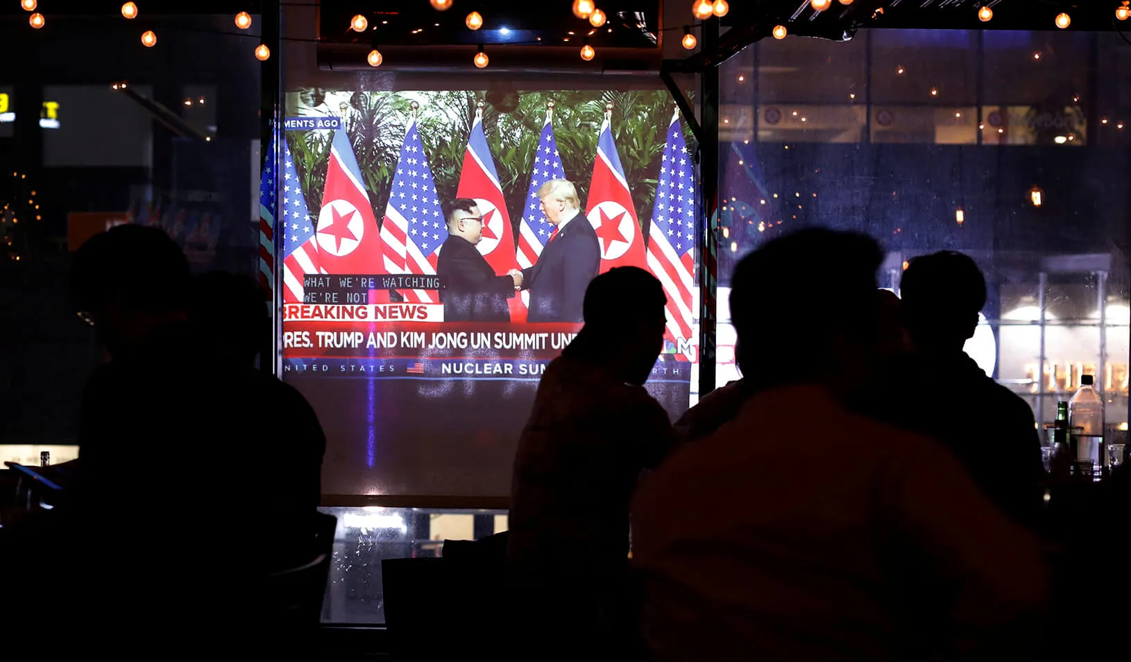 People gather in the WABar to watch a broadcast on television as U.S. President Donald Trump meets North Korean leader Kim Jong Un, Credit: Reuters/Andrew Kelly