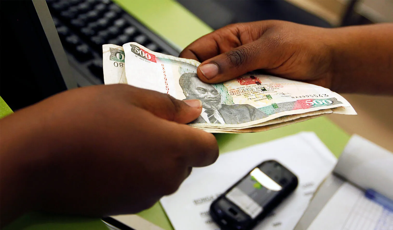 A customer conducts a mobile money transfer, known as M-Pesa, inside the Safaricom mobile phone care centre in the central business district of Kenya's capital Nairobi