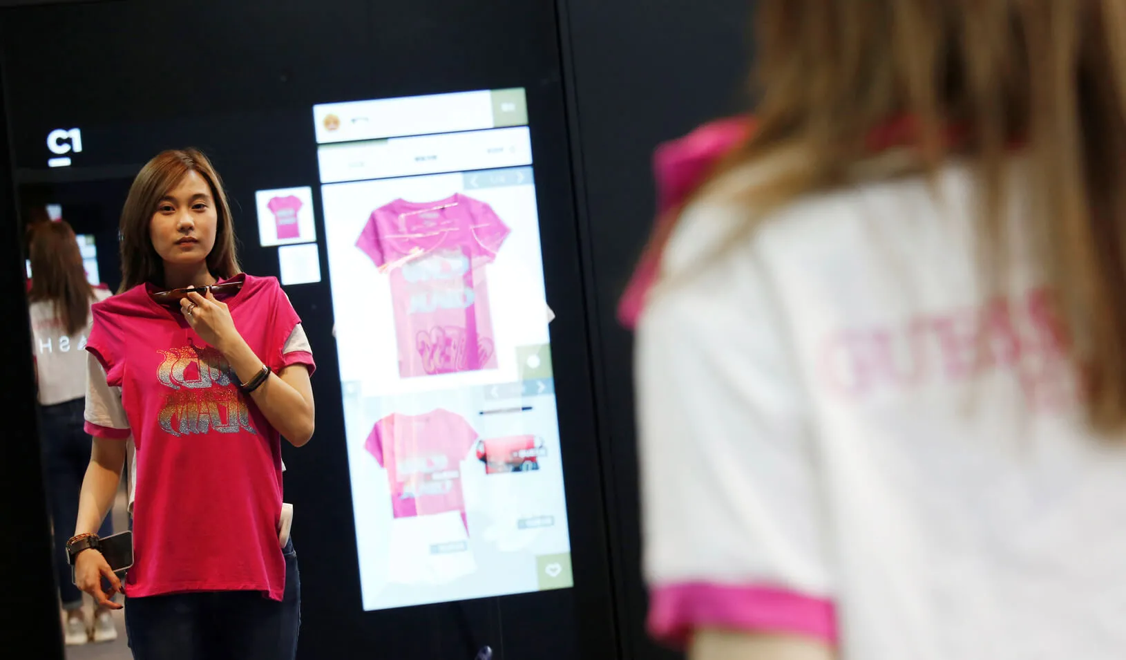 A model demonstrates Alibaba’s FashionAI technology, with the chosen item’s details being displayed on the mirror, at a pop-up store in partnership with fashion brand GUESS, on the sidelines of the Artificial Intelligence on Fashion and Textile Conference