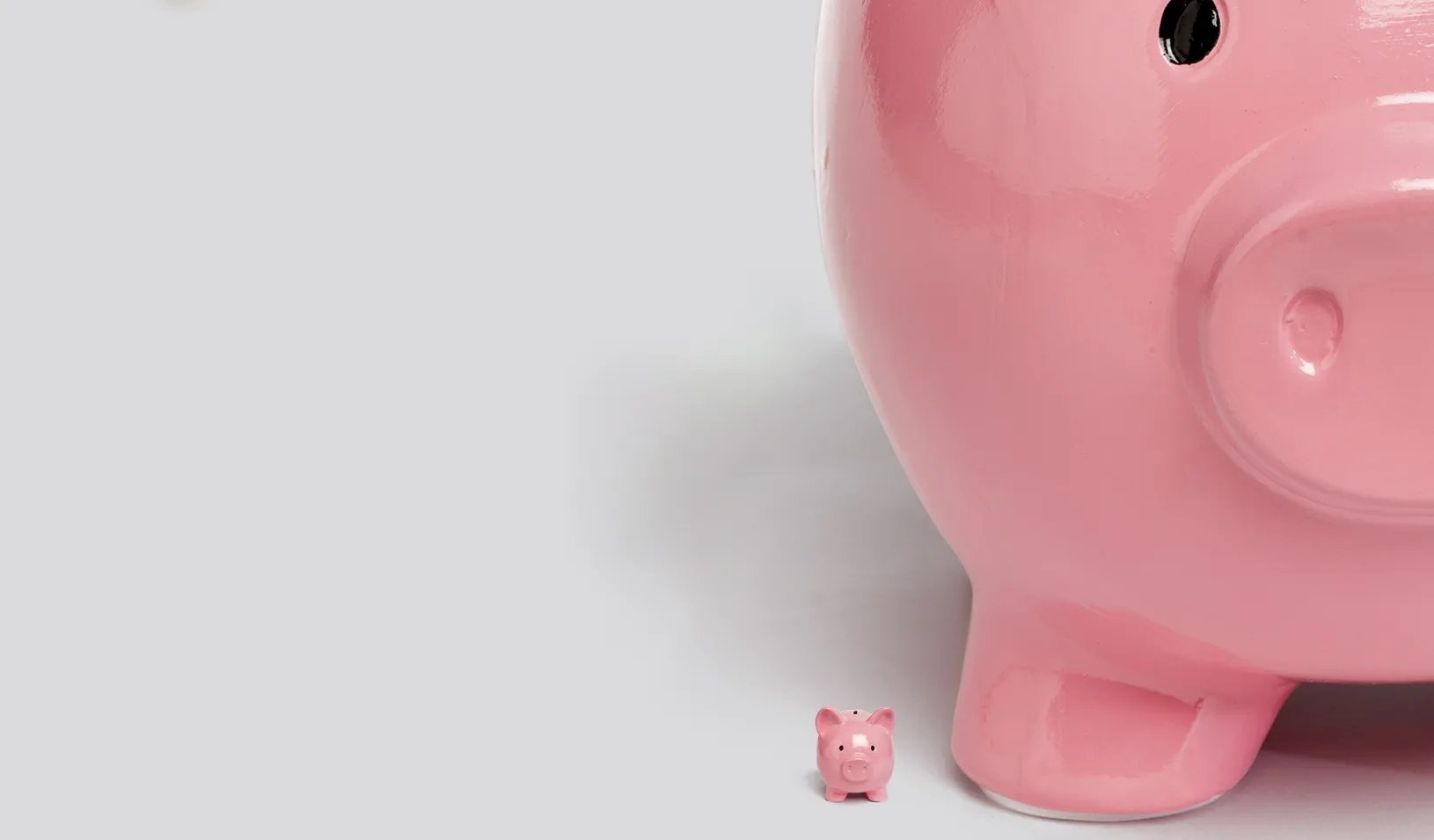  Illustration of a tiny pink piggy bank being dwarfed by a very large pink piggy bank. Credit: Alvaro Dominguez