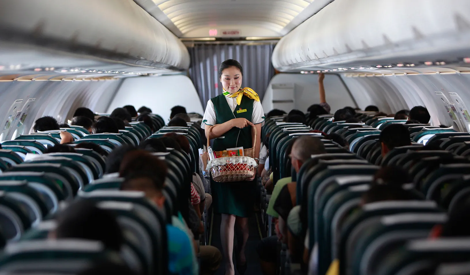 A flight attendant walking down the aisle of a plane