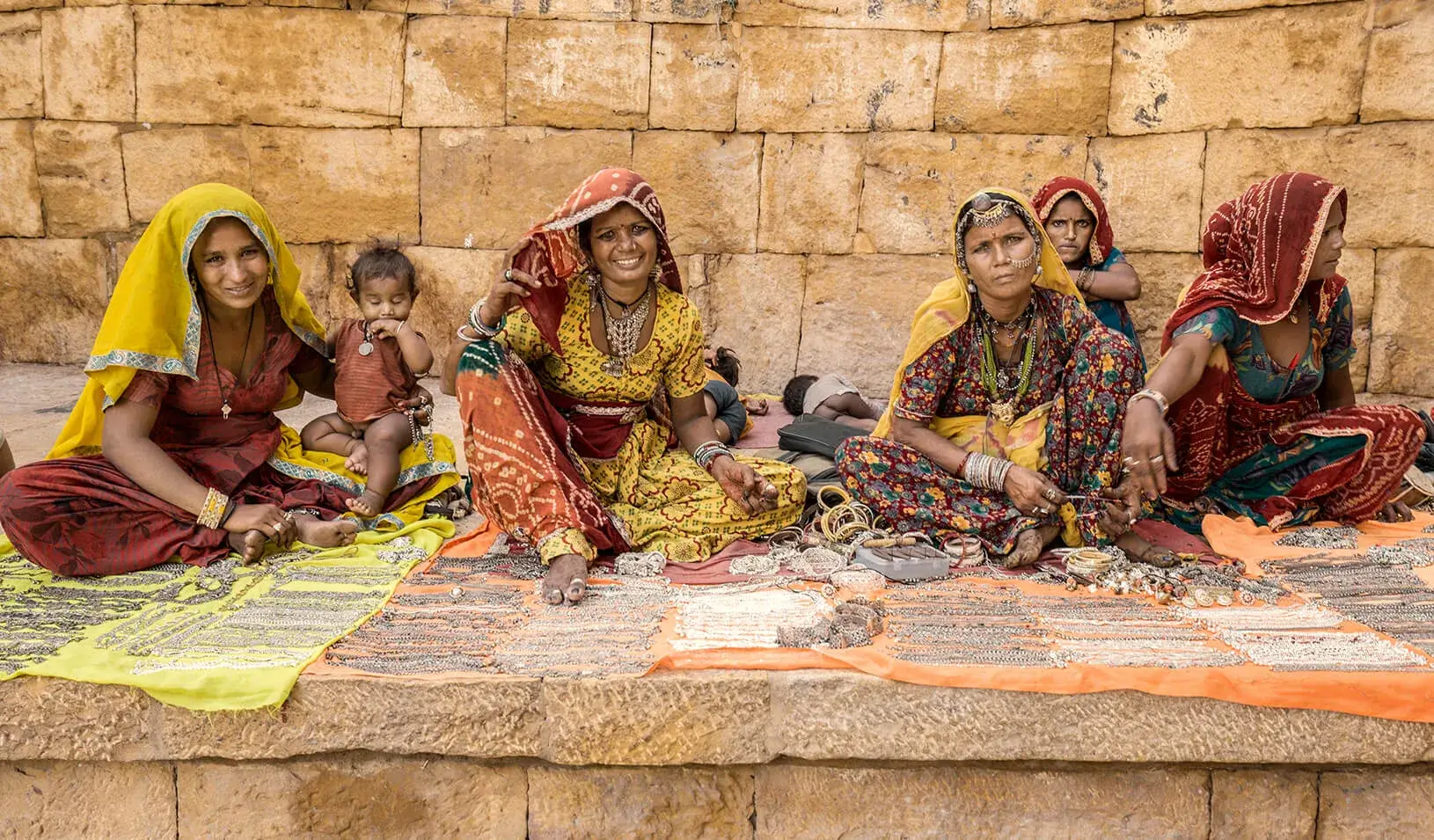 A group of women selling jewelry and handicrafts at the walls of the Jaisalmer fort in Rajasthan India. Credit: iStock/Aluxum
