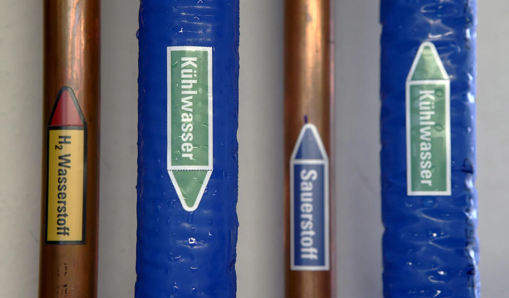 Pipes marked "Wasserstoff" (hydrogen), "Kuehlwasser" (coolant) and "Sauerstoff" (oxygen) are pictured at the "wind2hydrogen" pilot plant in Auersthal, Austria, Credit: Reuters/Heinz-Peter Bader