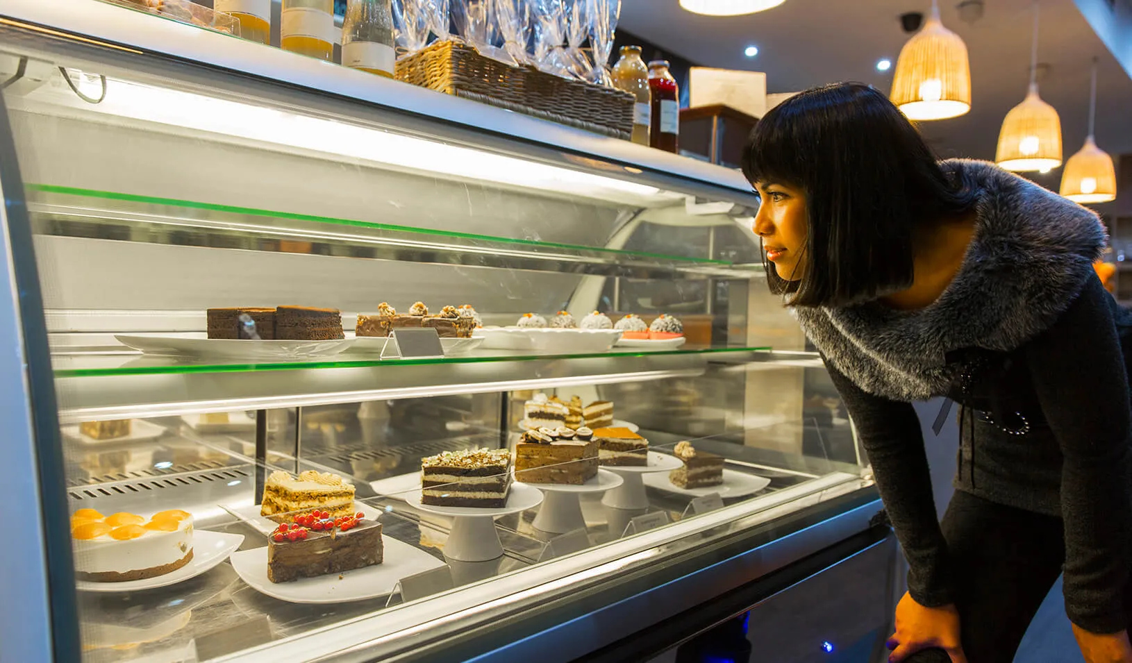 A woman looks at a case of desserts