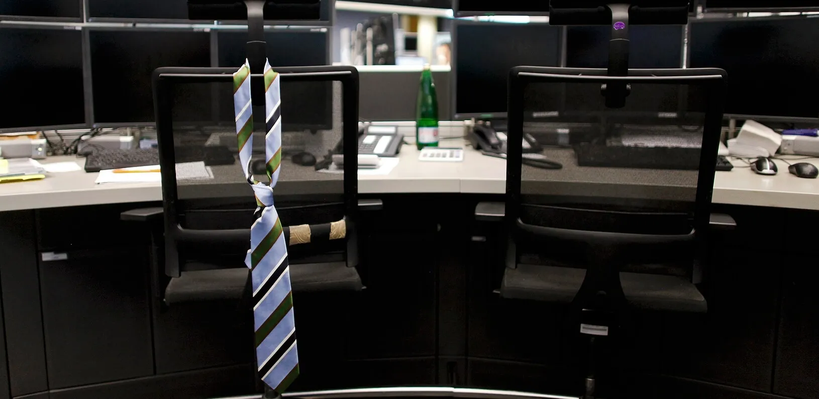 a tie hanging on the back of an empty work chair