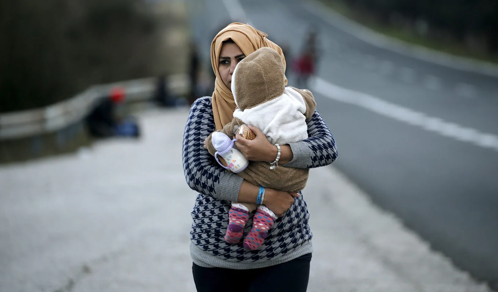A refugee mother carrying her child | Reuters/Yannis Behrakis