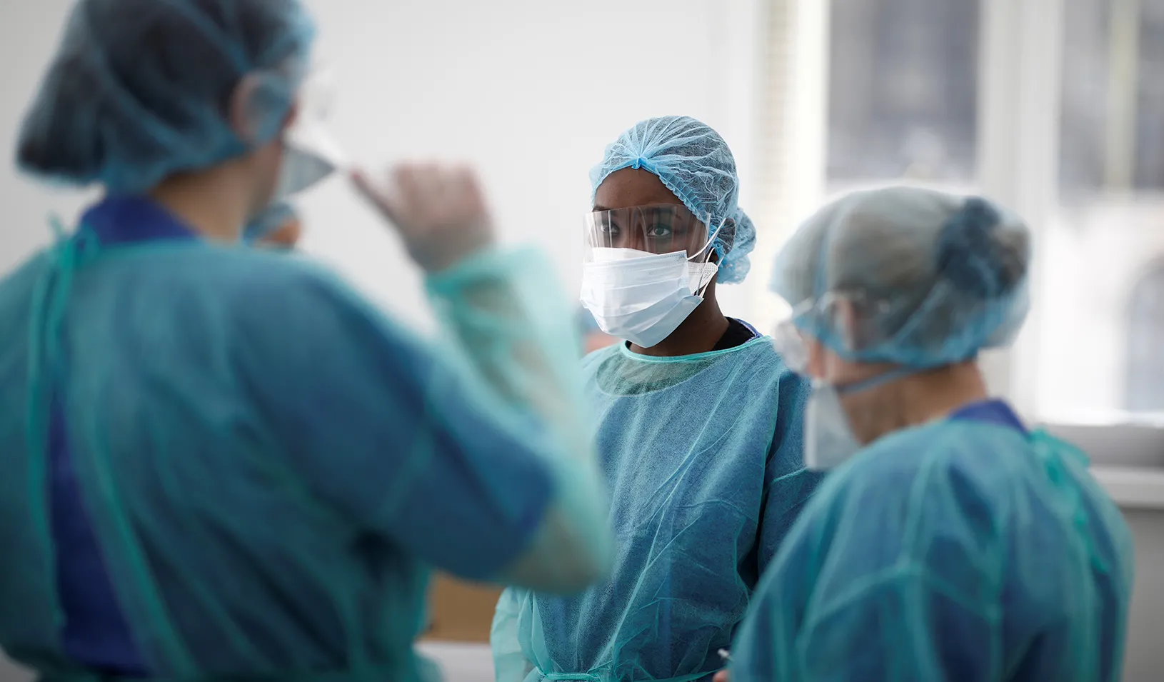 Medical staff, wearing protective suits and face masks, prepare material for medical consultations at an emergency COVID-19 center inside a gymnasium. Credit: Reuters/Benoit Tessier